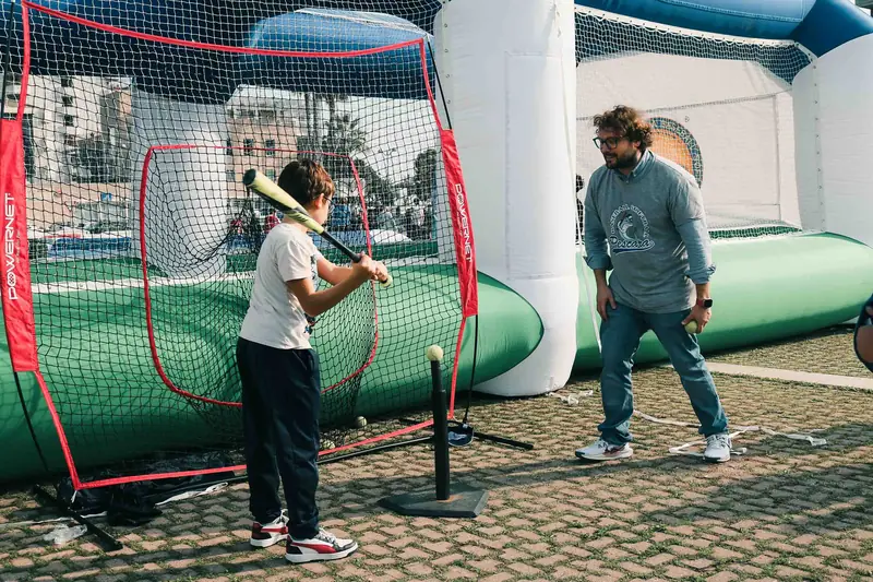 Un ragazzo alla battuta nella gabbia di baseball