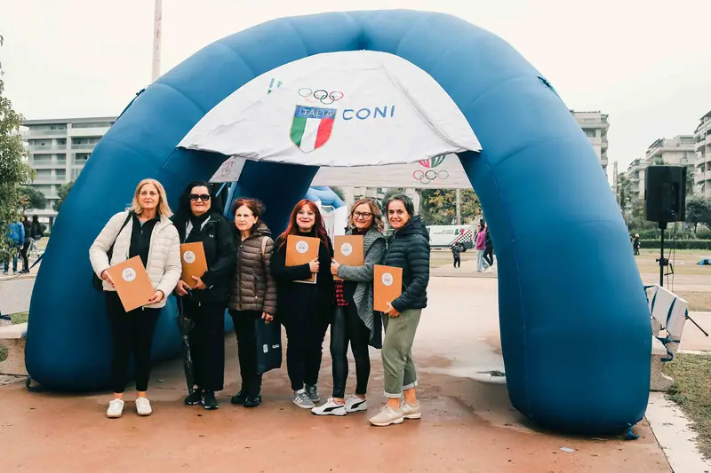 Foto di gruppo dello staff sotto l'arco gonfiabile del CONI