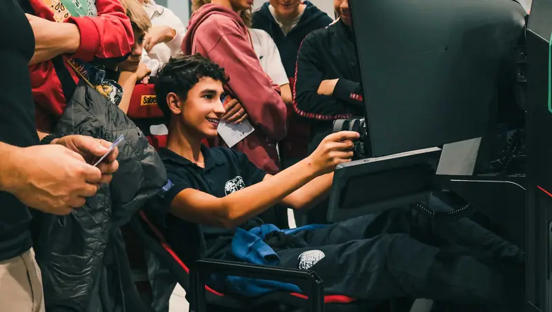 Un ragazzo alla postazione con simulatore sportivo digitale
