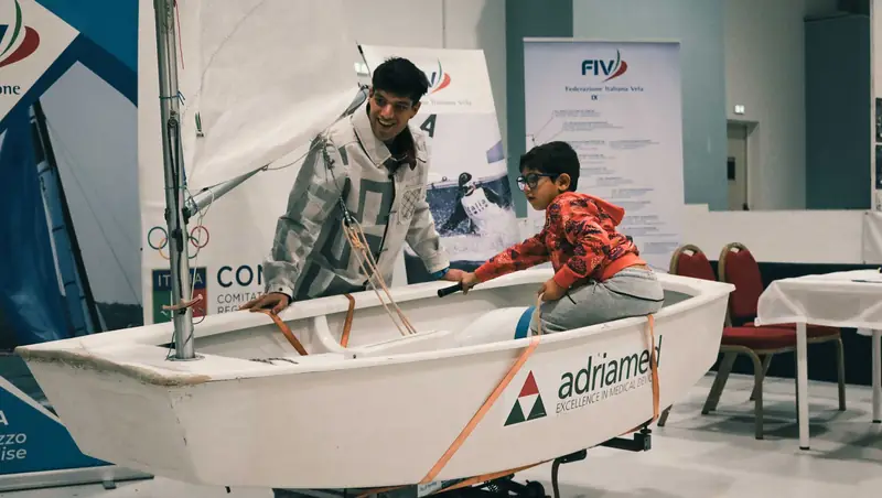 Un bambino a bordo dell'imbarcazione nella prova di vela
