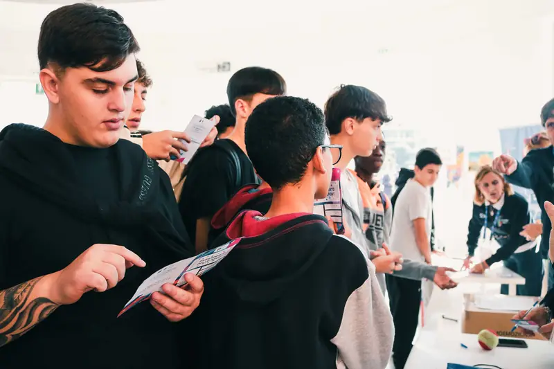 Ragazzi leggono il materiale informativo agli stand delle federazioni