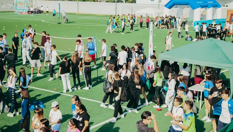 Vista dall'alto del campo con centinaia di studenti impegnati nelle attività sportive